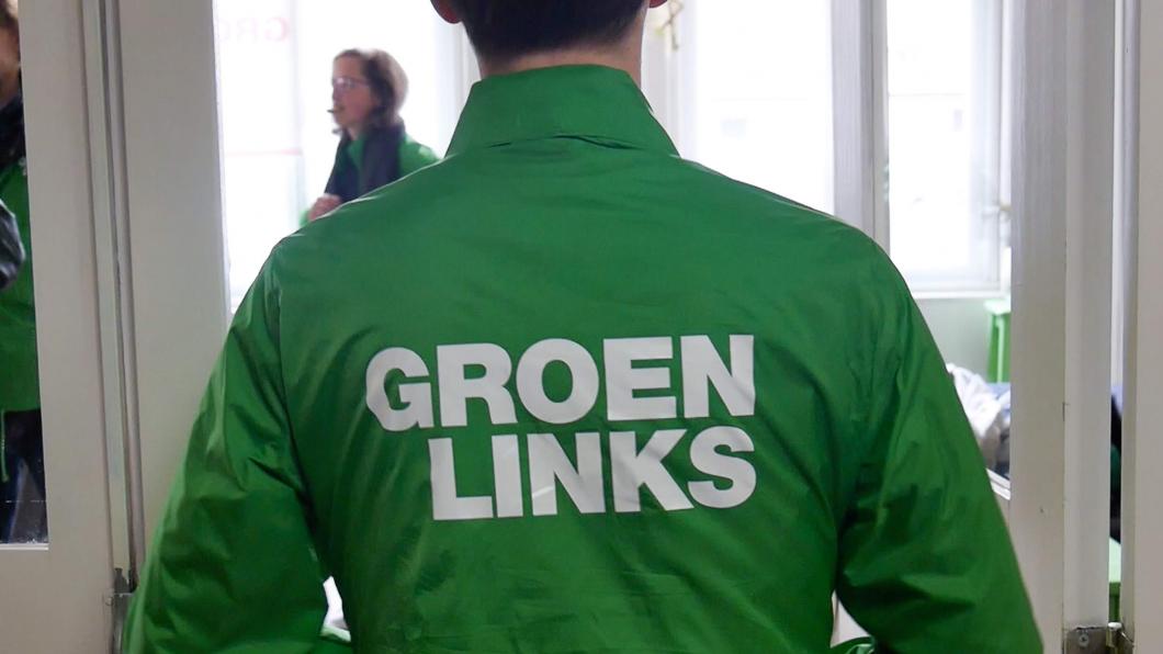 Een GroenLinks-vrijwilliger met een groene campagnejas aan