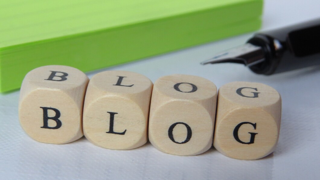 letters van het woord blog op dobbelsteenblokjes met groene achtergrond en vulpen