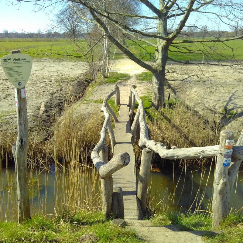 foto van wandelpad met brug over het kanaal
